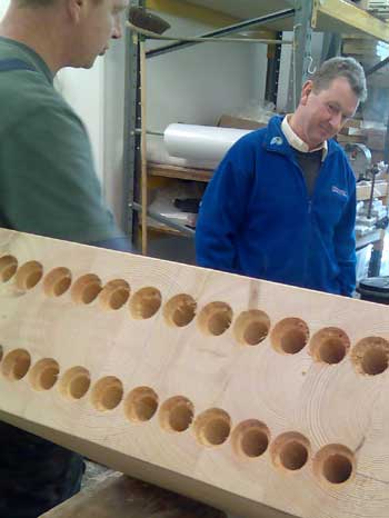 Clse up of large holes drilled into a laminated wood beam